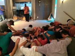 Men praying in Brenham
